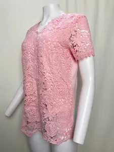 Close-up detail of the intricate pink rose pattern lace fabric on a women's short sleeve top