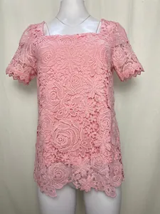 Nahaufnahme des eleganten rosa Oberteils aus floraler Hohlspitze mit quadratischem Ausschnitt.