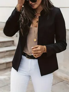 Detail view of a black stand collar blazer styled with gold accessories and white pants.