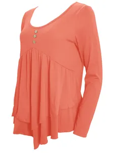 Detail of the wooden buttons and tiered pleated hem on this coral long-sleeved tunic