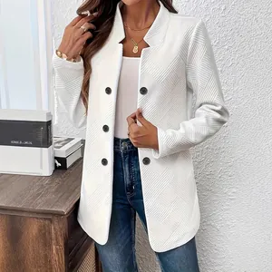 Detailed view of the elegant white textured fabric and button design of the women's coat.