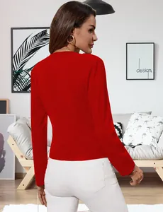 Vista trasera de una chaqueta de punto roja para mujer en un ambiente de salón cómodo y elegante.