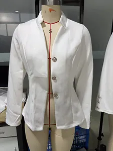 Detailansicht eines weißen Damen-Blazers mit verzierten Goldknöpfen auf einer Schaufensterpuppe