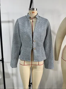 Nahaufnahme eines grauen strukturierten Blazers mit eleganten goldfarbenen Knöpfen