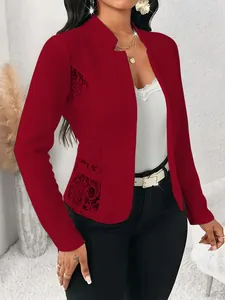 Detail shot of a woman in an elegant red slim-fit blazer with intricate lace patchwork.
