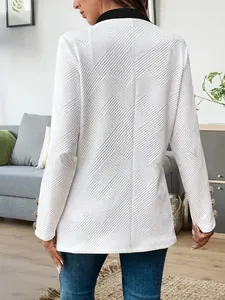 Detailed back view of white textured blazer with black collar and gold sleeve buttons.