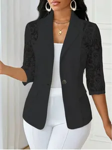Détail du blazer noir avec des manches en dentelle délicate et un bouton rose doré.