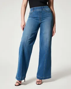 Full detail view of women's mid-rise wide-leg washed denim jeans featuring front seam design