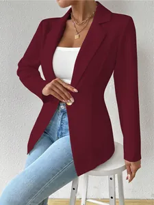 Detail van een elegante bordeauxrode blazer met lange mouwen voor dames en gouden knoop.