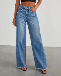 Close-up detail of wide-leg blue jeans with raw frayed hem and side seam stitching