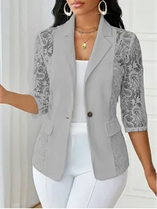 Gros plan d'un blazer gris à empiècements en dentelle, revers élégant et bouton