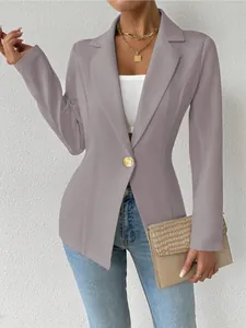 Detail van een mauve getailleerde blazer met lange mouwen en een chique gouden knoop