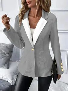 Détail d'un blazer gris à revers blanc, tissu texturé et boutons dorés élégants