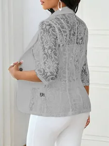 Gros plan sur la texture dentelle florale complexe des manches et du dos de ce blazer gris chic.
