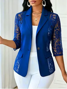 Détail d'un blazer bleu roi avec des manches en dentelle ajourée et un col à revers.