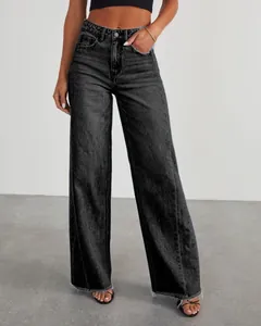 Detail view of high-waisted wide-leg jeans with unique side seams and frayed hem.