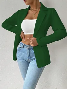 Detailweergave van een stijlvolle groene damesblazer met lange mouwen en blauwe jeans