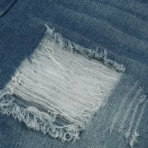 Macro-detail van een distressed gescheurd gat op een blauwe denim korte broek