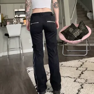 Achteraanzicht van zwarte flared jeans voor dames met lage taille en zilveren ritsen