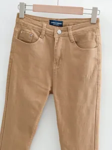 Détail d'un jean évasé rétro à taille haute extensible en marron kaki.