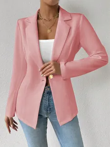 Detailopname van een roze damesblazer met lange mouwen en gouden knoop voor een chique look