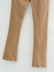 Gros plan d'un jean évasé marron rétro avec des ourlets effilochés et une coupe élastique