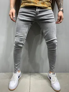 Detailed macro view showing the fit of men's slim-fit stretch skinny jeans in light gray