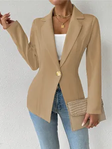 Detail van een camelkleurige blazer met lange mouwen en een gouden tailleknoop.