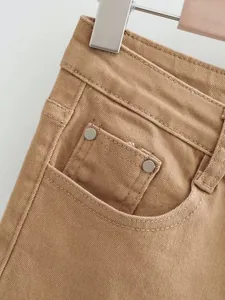 Gros plan sur les détails de la poche et la couture taille haute d'un jean évasé marron