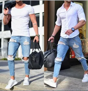 Detailed view of men's light blue distressed skinny denim jeans worn by a model
