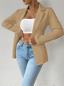Kaki blazer met reverskraag gedragen over een witte crop top en lichtblauwe jeans