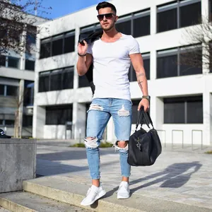 Modern mens light blue skinny ripped jeans with distressed details and ankle zippers