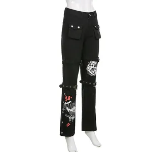 Detail van zwarte streetwear-denimbroek met grafische prints en metalen gespriemen