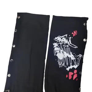 Detail view of street style black jeans with side snap buttons and bone graphic print.