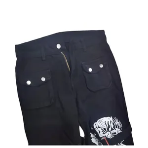 Close-up detail of black streetwear denim pants with flap pockets and graphic print