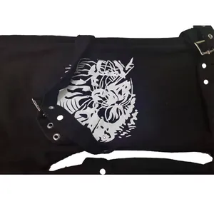 Detailed close-up of tiger print and metal buckle on black streetwear denim pants