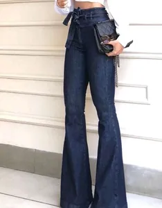 Détail d'un jean évasé à taille haute avec une ceinture à nouer en denim bleu foncé.