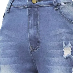 Close-up of light blue ripped denim jeans detailing the distressed texture and front button