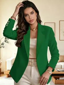 Detailed shot of an elegant emerald green blazer featuring three golden sleeve buttons on model