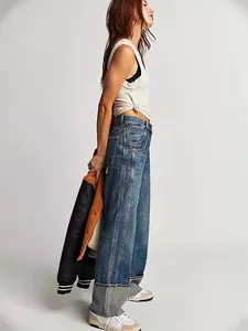 Jean droit délavé à taille moyenne pour femme avec larges revers gris aux chevilles.