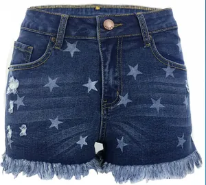 Detailed view of high-waisted denim shorts featuring blue star print and fringe hem