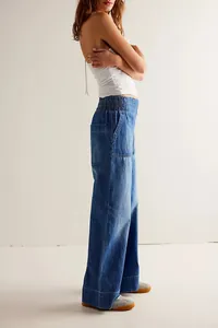 Side view detail of stylish low-rise wide-leg denim trousers with elastic waistband