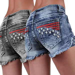 Detalle de shorts vaqueros con bordado de estrellas y dobladillo deshilachado en bolsillos.