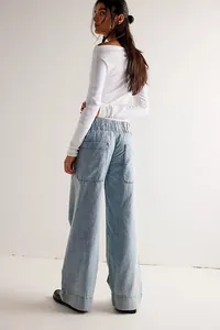 Close-up showing the back fit of loose wide-leg denim pants with large utility pockets