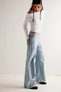 Professional model wearing light blue wide-leg denim pants with a white off-the-shoulder top