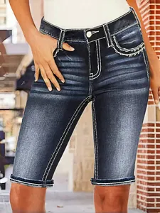 Gros plan sur un short en jean ajusté avec surpiqûres blanches et broderies