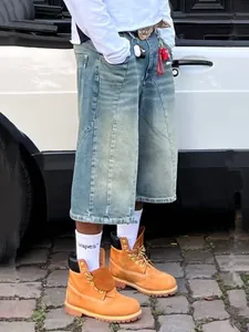 Full outdoor styling view of loose-fit retro washed denim shorts and street boots