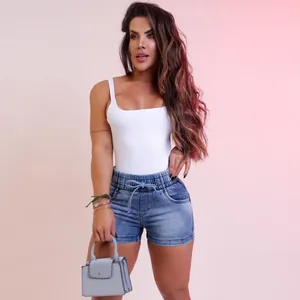 Vue en pied montrant la coupe du short en jean ajusté et du body blanc élégant