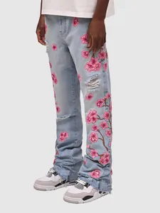 Detailed shot of men's straight-leg jeans with pink cherry blossom embroidery