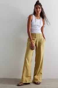 Full length view of a fashion model wearing mustard yellow wide-leg denim trousers